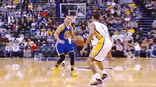 A Basketball Player Wearing A Golden State Warriors Jersey Is Dribbling A Ball GIF