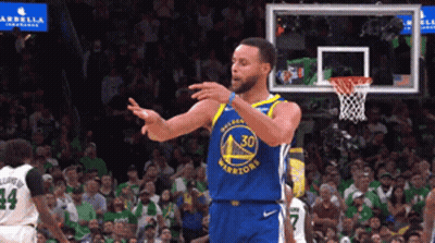 a basketball player wearing a golden state warriors jersey is standing in front of a crowd
