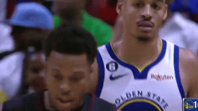 A Basketball Player Wearing A Golden State Warriors Jersey Is Standing Next To Another Basketball Player . GIF