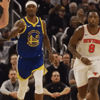 A Basketball Player Wearing A Golden State Warriors Jersey Runs Past Another Player Wearing A New York Knicks Jersey GIF