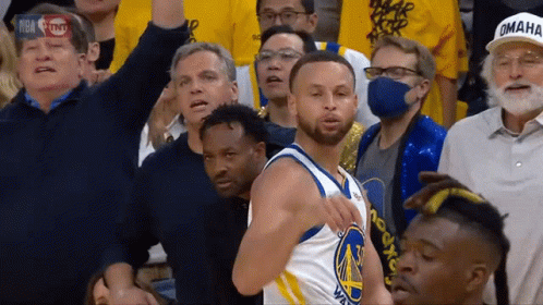 A Basketball Player Wearing A Golden State Warriors Jersey Stands In Front Of A Crowd GIF