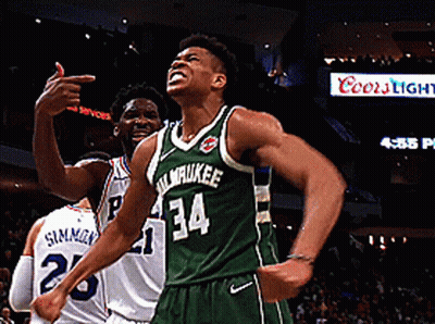 A Basketball Player Wearing A Green Milwaukee Jersey Celebrates GIF