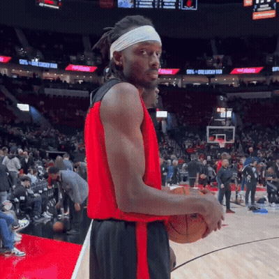 A Basketball Player Wearing A Headband Is Holding A Basketball On A Basketball Court . GIF