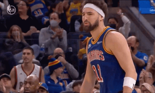 A Basketball Player Wearing A Headband Is Standing In Front Of A Crowd At A Basketball Game . GIF