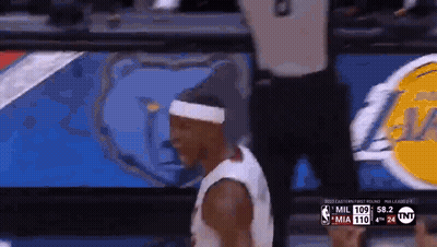 A Basketball Player Wearing A Headband Is Walking On The Court During A Game . GIF