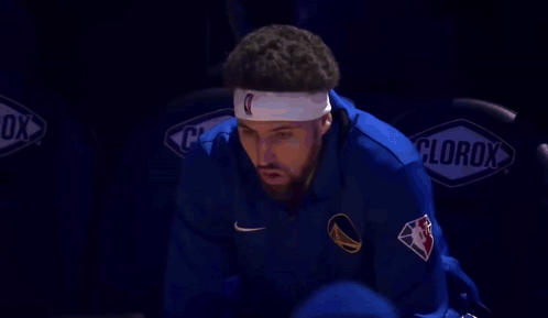 A Basketball Player Wearing A Headband With The Letter C On It Is Sitting In The Bleachers . GIF