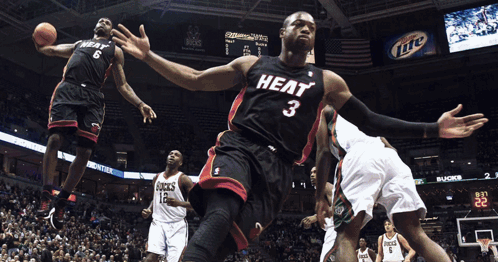 A Basketball Player Wearing A Heat Jersey Jumps In The Air To Catch The Ball GIF