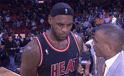 A Basketball Player Wearing A Heat Jersey Talks To A Reporter GIF