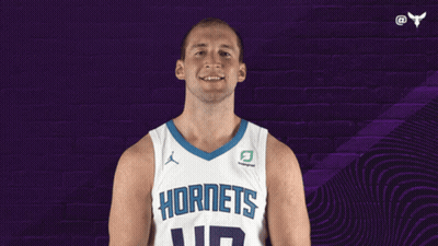 A Basketball Player Wearing A Hornets Jersey Is Smiling GIF