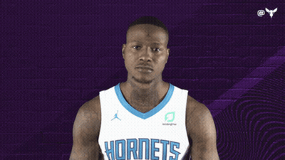 A Basketball Player Wearing A Hornets Jersey Points Up GIF