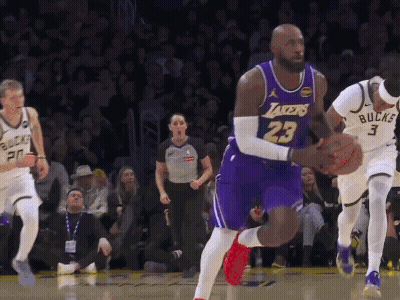 A Basketball Player Wearing A Lakers Jersey Is Dribbling The Ball GIF