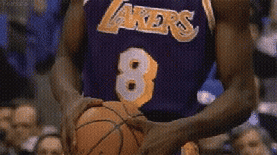 A Basketball Player Wearing A Lakers Jersey Is Holding A Basketball In His Hands . GIF