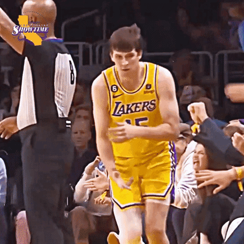 A Basketball Player Wearing A Lakers Jersey Is Standing In Front Of A Crowd GIF