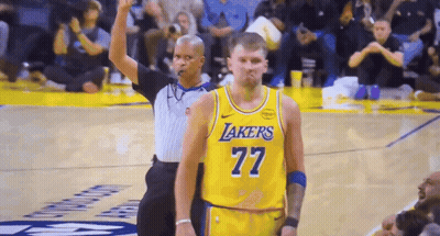 A Basketball Player Wearing A Lakers Jersey Is Standing Next To A Referee GIF
