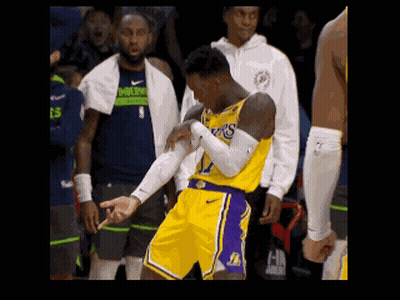 A Basketball Player Wearing A Lakers Jersey Is Standing On The Court With His Arms Crossed GIF