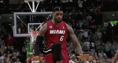 A Basketball Player Wearing A Miami Jersey Is Jumping In The Air During A Game . GIF