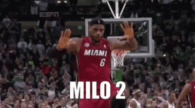 A Basketball Player Wearing A Miami Jersey Is Waving His Hands In The Air . GIF