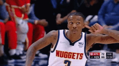 A Basketball Player Wearing A Nuggets Jersey Is Pointing GIF