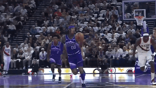 A Basketball Player Wearing A Number 00 Jersey Dribbles The Ball GIF
