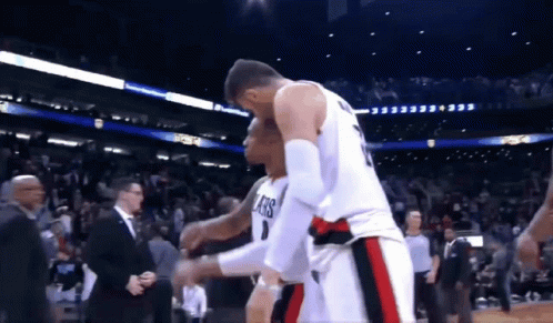 A Basketball Player Wearing A Number 1 Jersey Is Hugging Another Player GIF
