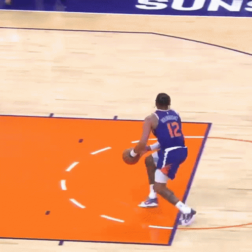 A Basketball Player Wearing A Number 12 Jersey Is Dribbling The Ball GIF