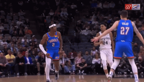 A Basketball Player Wearing A Number 27 Jersey Stands Between Two Other Players GIF