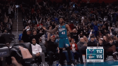 A Basketball Player Wearing A Number 41 Jersey Stands In Front Of A Crowd GIF