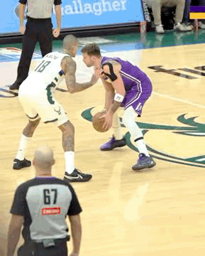 A Basketball Player Wearing A Number 67 Jersey Dribbles The Ball GIF