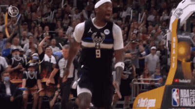 A Basketball Player Wearing A Number 9 Jersey Stands In Front Of A Crowd GIF