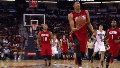 A Basketball Player Wearing A Pelican Jersey Is Jumping In The Air With The Ball GIF