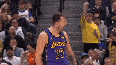 A Basketball Player Wearing A Purple Lakers Jersey Celebrates In Front Of A Crowd GIF