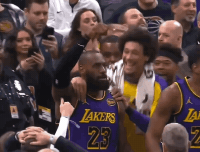 A Basketball Player Wearing A Purple Lakers Jersey Is Surrounded By Fans GIF