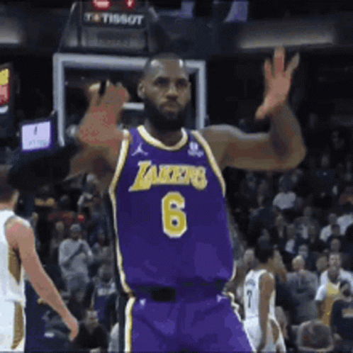 A Basketball Player Wearing A Purple Lakers Jersey Is Waving His Hand GIF