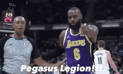 A Basketball Player Wearing A Purple Lakers Jersey Shakes Hands With A Referee During A Game . GIF