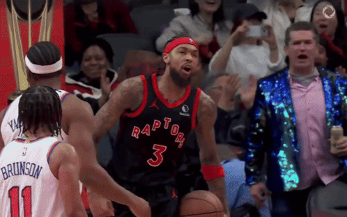 A Basketball Player Wearing A Raptors Jersey Is Dribbling The Ball GIF
