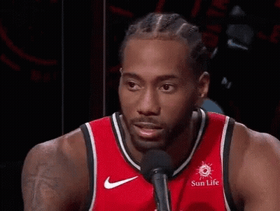 A Basketball Player Wearing A Red Jersey Is Smiling And Talking Into A Microphone . GIF