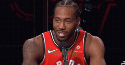 A Basketball Player Wearing A Red Jersey Is Talking Into A Microphone . GIF