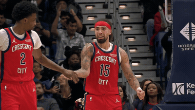 A Basketball Player Wearing A Red Jersey That Says Crescent City Shakes Hands With Another Player GIF