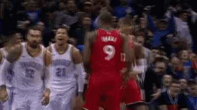 A Basketball Player Wearing A Red Jersey With The Number 9 On It Stands In Front Of A Crowd . GIF