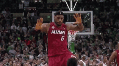 A Basketball Player Wearing A Red Miami Jersey Is Jumping In The Air . GIF