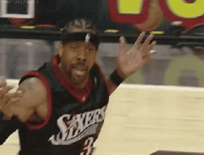 A Basketball Player Wearing A Sixers Jersey Is Waving His Hand On A Court . GIF