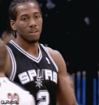 A Basketball Player Wearing A Spurs Jersey Is Standing In Front Of A Fence . GIF