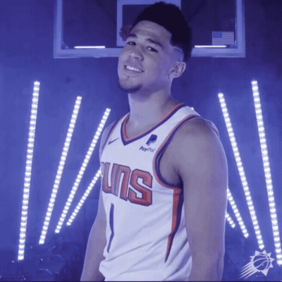A Basketball Player Wearing A Suns Jersey Stands In Front Of A Basketball Hoop GIF
