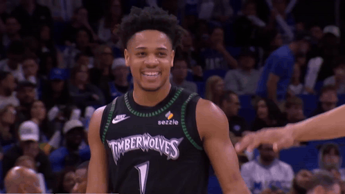 A Basketball Player Wearing A Timberwolves Jersey Smiles At The Camera GIF