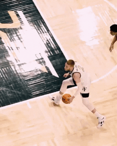 A Basketball Player Wearing A White Jersey With The Letter U On It GIF