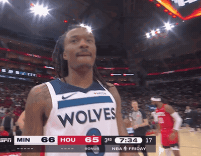 A Basketball Player Wearing A Wolves Jersey Looks At The Camera GIF