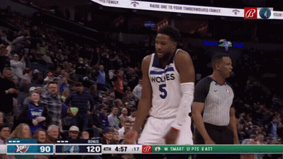 A Basketball Player Wearing A Wolves Jersey Stands In Front Of A Crowd GIF