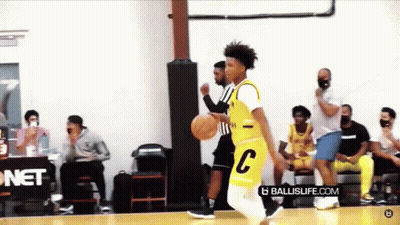 A Basketball Player Wearing A Yellow Jersey With The Letter C On It Is Dribbling The Ball On A Court . GIF