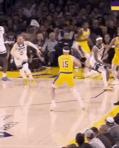 A Basketball Player Wearing A Yellow Jersey With The Number 15 On It Is Dribbling The Ball During A Game . GIF