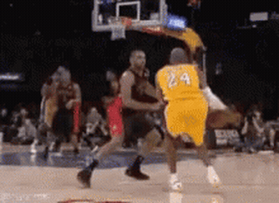 A Basketball Player Wearing A Yellow Jersey With The Number 24 On It Is Being Blocked By Another Player . GIF